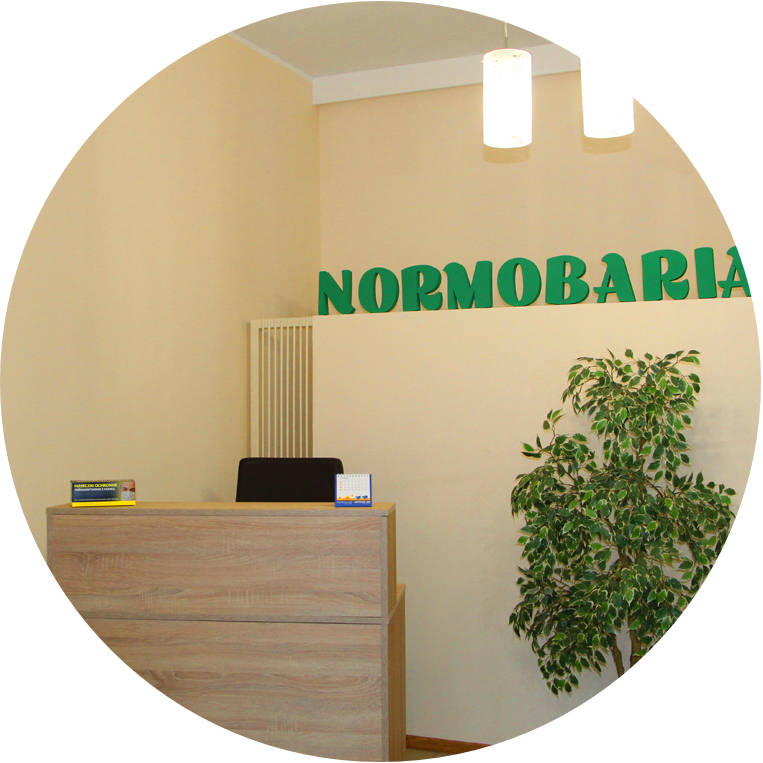 Recepcja Normobaria — poczekalnia z logo na ścianie